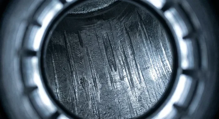 Vue endoscopique de rayures de cylindre profondes (bore scoring) sur un moteur Porsche.